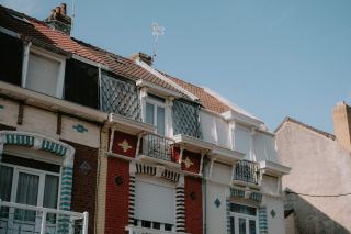 Un artisan réalise une isolation extérieure sur la façade d'une maison mitoyenne en rénovation