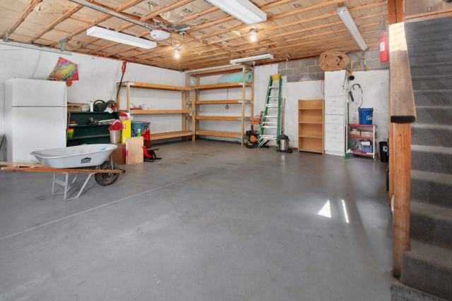 Garage attenant avant travaux, plafond et porte non isolés Intérieur d'un garage attenant, porte fermée et plafond en béton brut