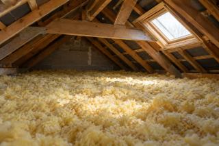 Flocons de laine de verre soufflés sur le plancher d'un comble perdu
